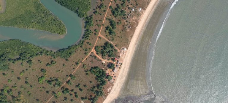 aerial view of green grass field beside body of water during daytime